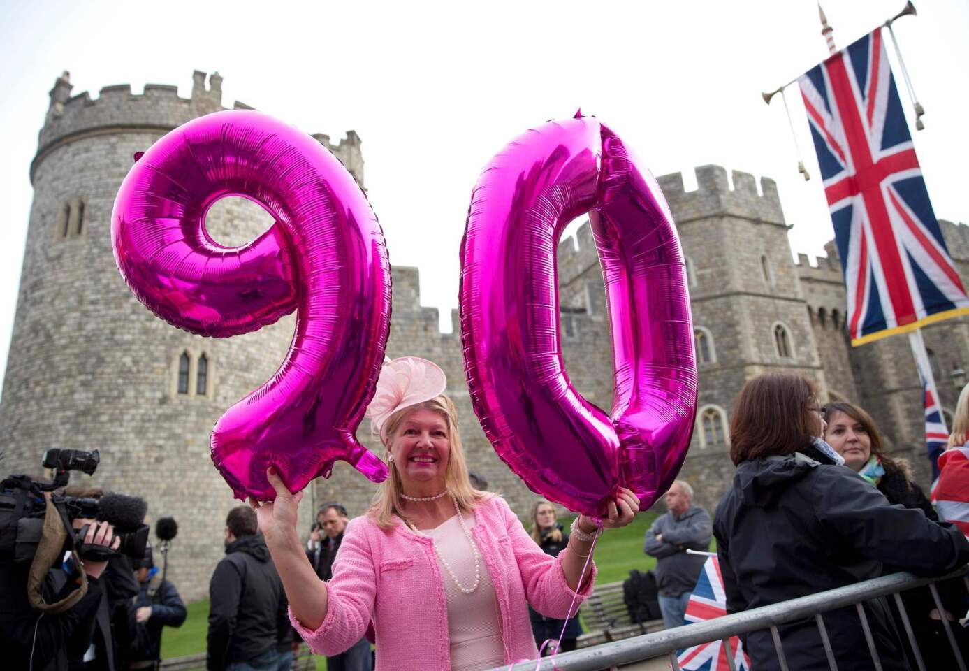 A royal supporter poses outside Windsor Castle as Britain's Queen Elizabeth II celebrates her 90th birthday on April 21.