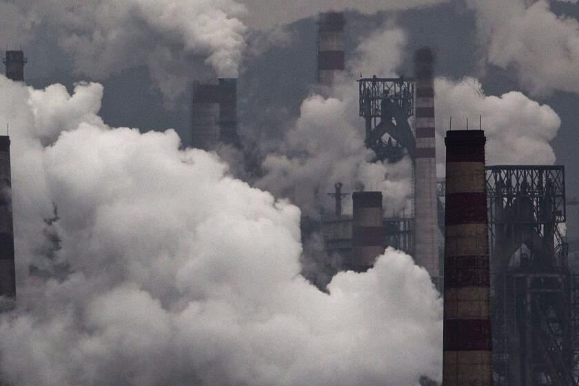 Smoke billows from smokestacks and a coal-fired generator at a steel factory in China. Scientists have developed a new method for tracking countries' compliance with the goals set forth in the Paris Agreement.