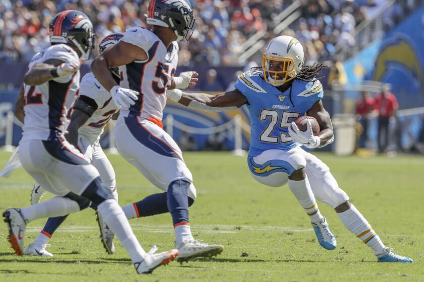 CARSON, CA, SUNDAY, OCTOBER 6, 2019 - Los Angeles Chargers running back Melvin Gordon (25) tries to avoid Broncos defenders during a first half run at Dignity Health Sports Park. (Robert Gauthier/Los Angeles Times)