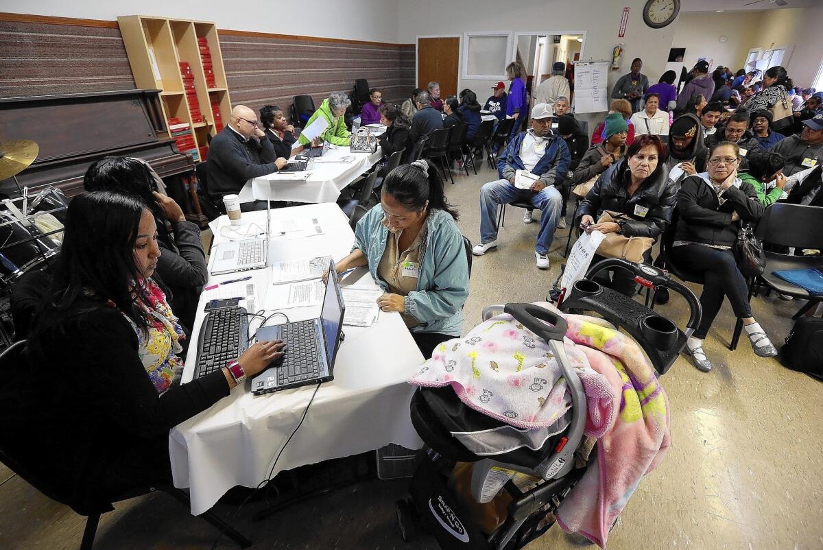 Workers help applicants register for healthcare insurance during an enrollment fair at the Bay Area Rescue Mission in Richmond, Calif.