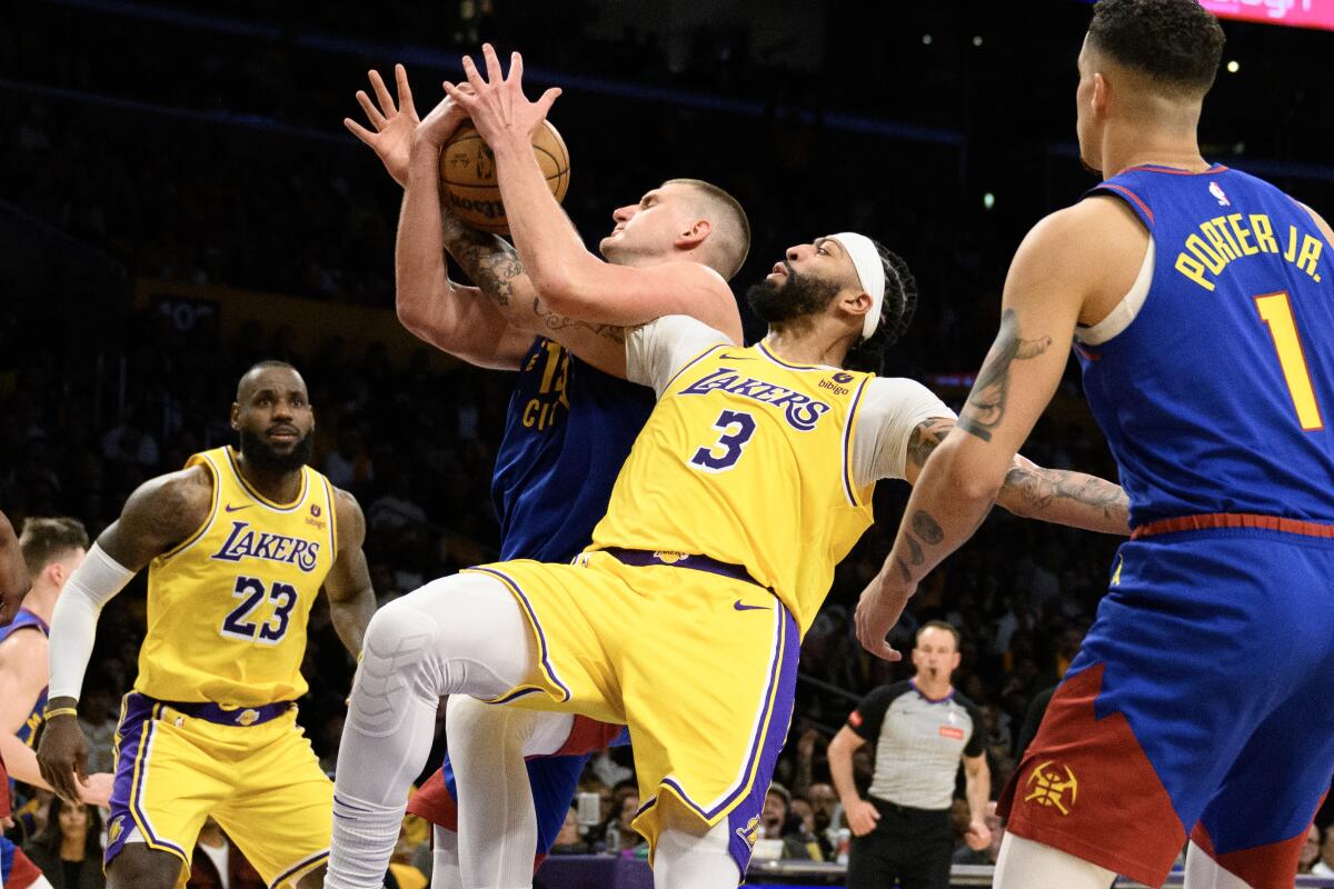 Lakers forward Anthony Davis battles Nuggets center Nikola Jokic for a rebound 