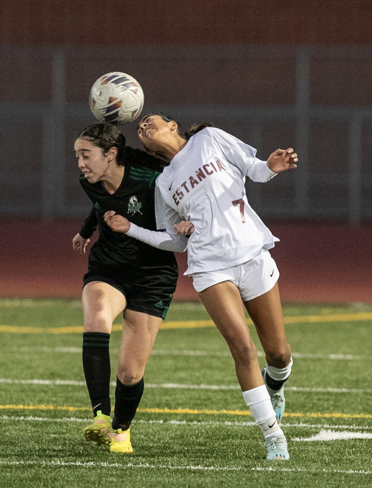 Costa Mesa's Alexys Lopez, left, goes up for a header against Estancia's Ana Pacheco during Tuesday's match.