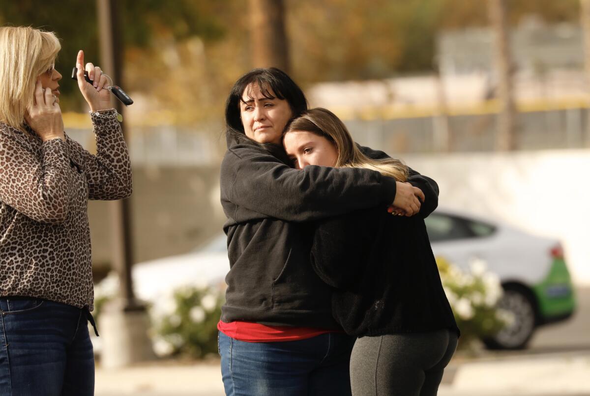 Una madre se reúne con su hija en las afueras de Saugus High School, donde al menos una persona murió y cuatro resultaron heridas cuando un pistolero abrió fuego contra el campus de Santa Clarita a primeras horas del jueves.