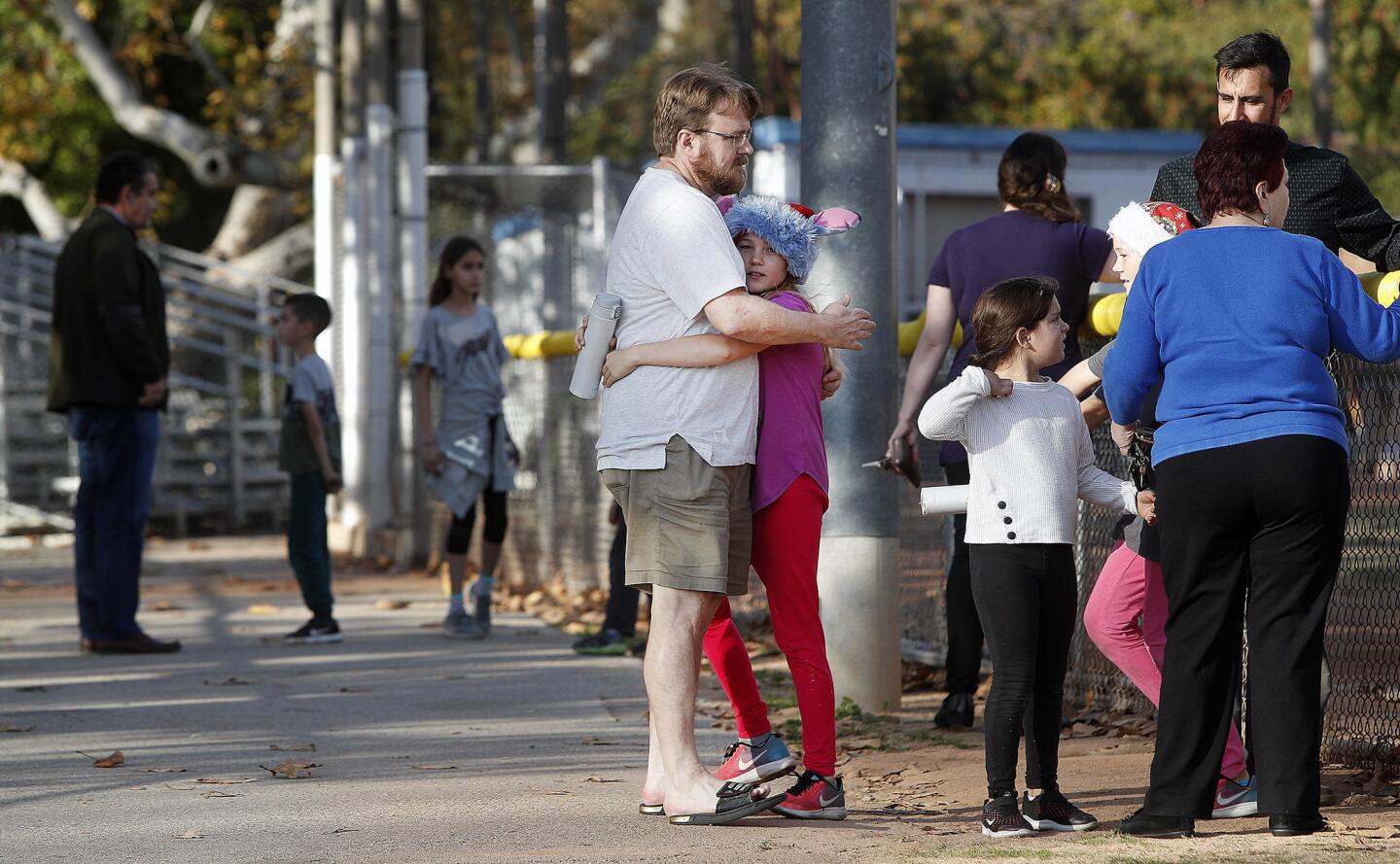Christian Lindke, of Glendale, hugs his daughter Nora, 10, the first of his two girls to reach him at at Babe Herman Little League Field where the girls were relocated to due to a bomb scare at Verdugo Woodland Elementary School in Glendale on Monday, December 17, 2018. The school was evacuated and students were taken to be picked up at Babe Herman Little League Field which happens to be behind the school.