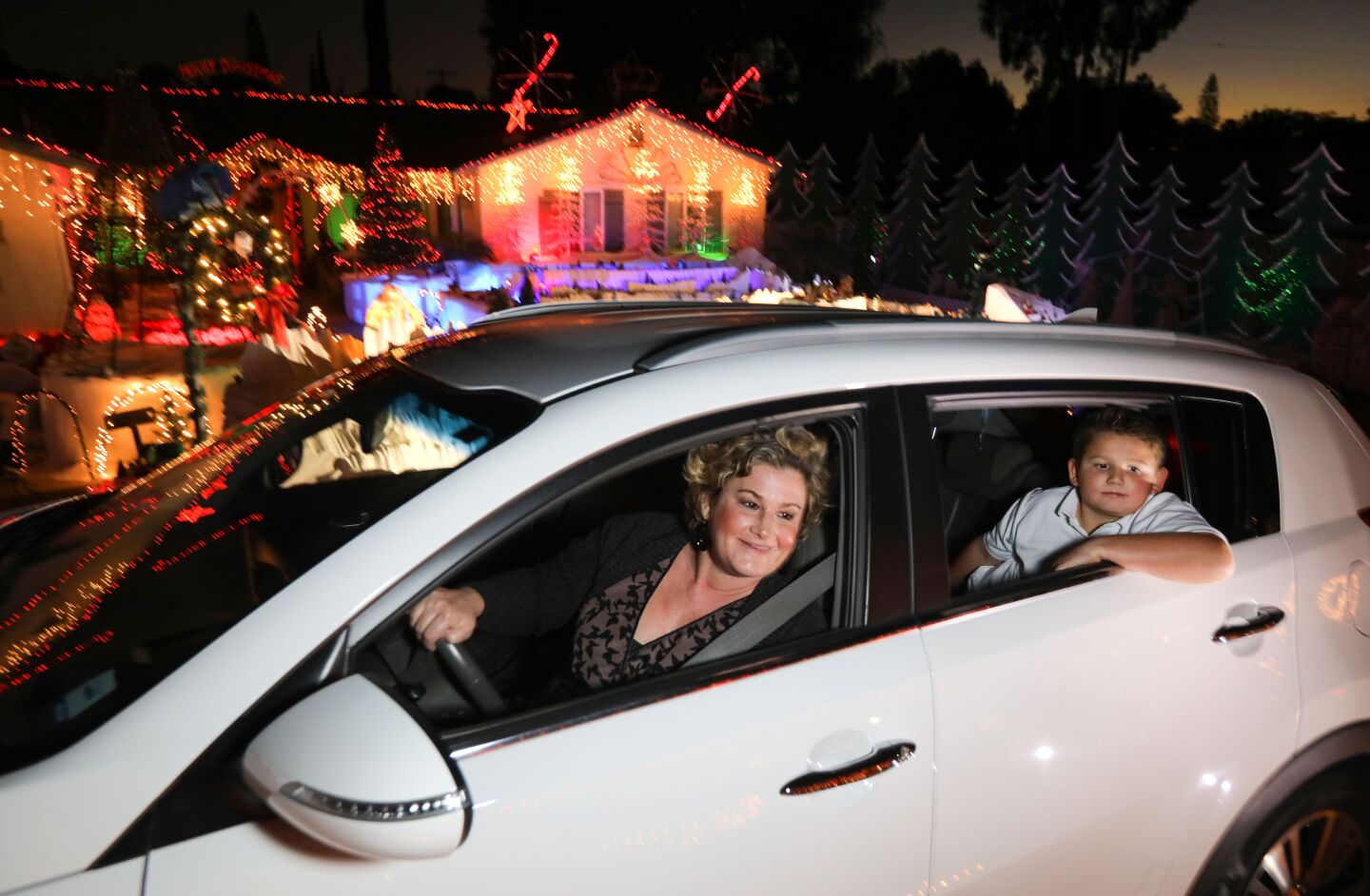 Jesse Taylor and her 8-year-old son Logan enjoy the Christmas decorations on both side of the circular driveway of the home of Mack Schreiber on Reche Road in Fallbrook.