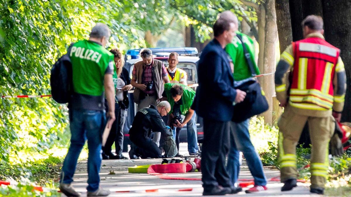 Members of a bomb disposal team check items at the scene where a knife-wielding man attacked passengers on a bus July 20 in Luebeck, Germany. Authorities feared a bag belonged to the attacker and could contain explosives.