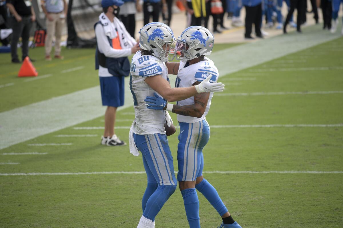 Detroit Lions tight end T.J. Hockenson is congratulated by wide receiver Marvin Jones.