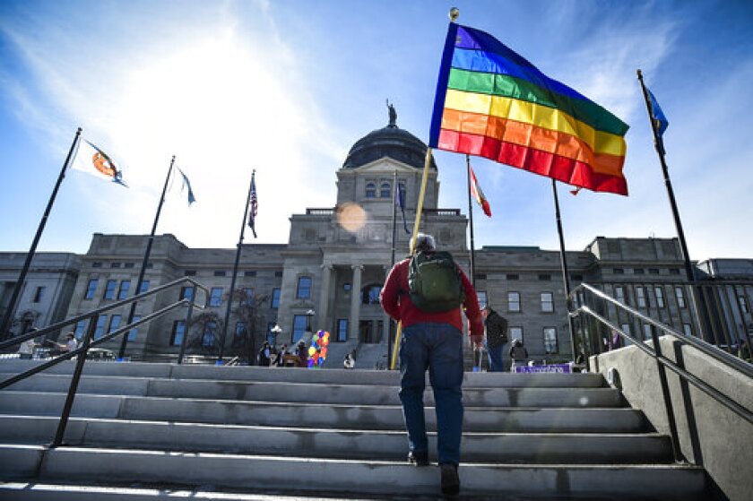 FILE - In this March 15, 2021, file photo demonstrators gather on the step of the Montana State Capitol protesting anti-LGBTQ+ legislation in Helena, Mont. The Montana Senate Judiciary Committee voted Thursday, March 18 to advance two bills targeting transgender youth despite overwhelming testimony opposing the measures. The measures would ban gender affirming surgeries for transgender minors and ban transgender athletes from participating in school and college sports. Both bills have already passed the Montana House. They head next to votes by the GOP-controlled Montana Senate. (Thom Bridge/Independent Record via AP, File)