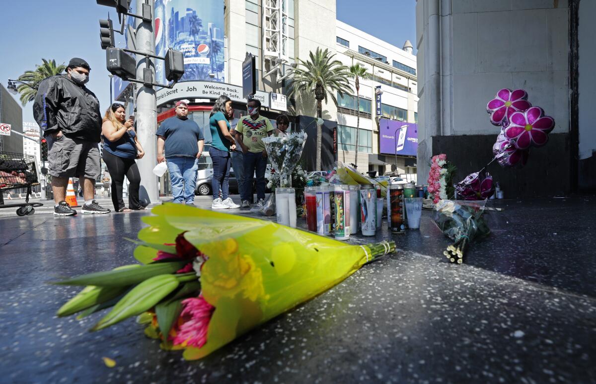 Flowers and candles mark a sidewalk memorial in Hollywood