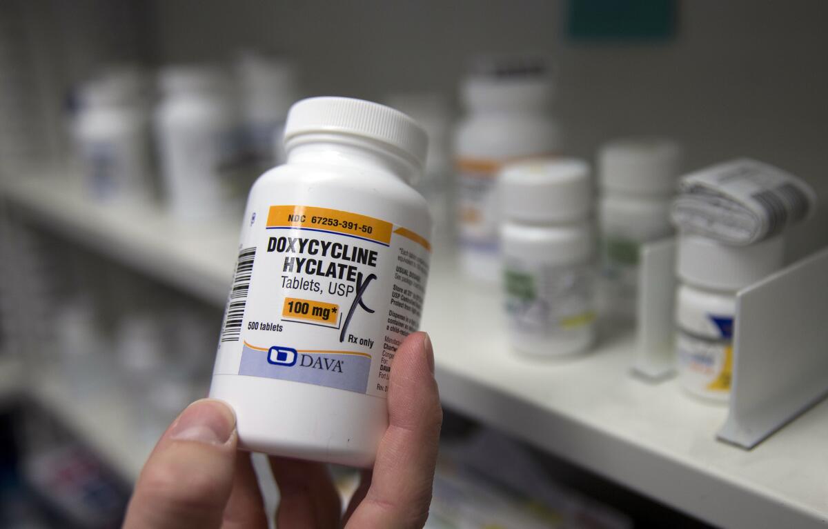 A pharmacist in Sacramento holds a bottle of the antibiotic doxycycline hyclate.
