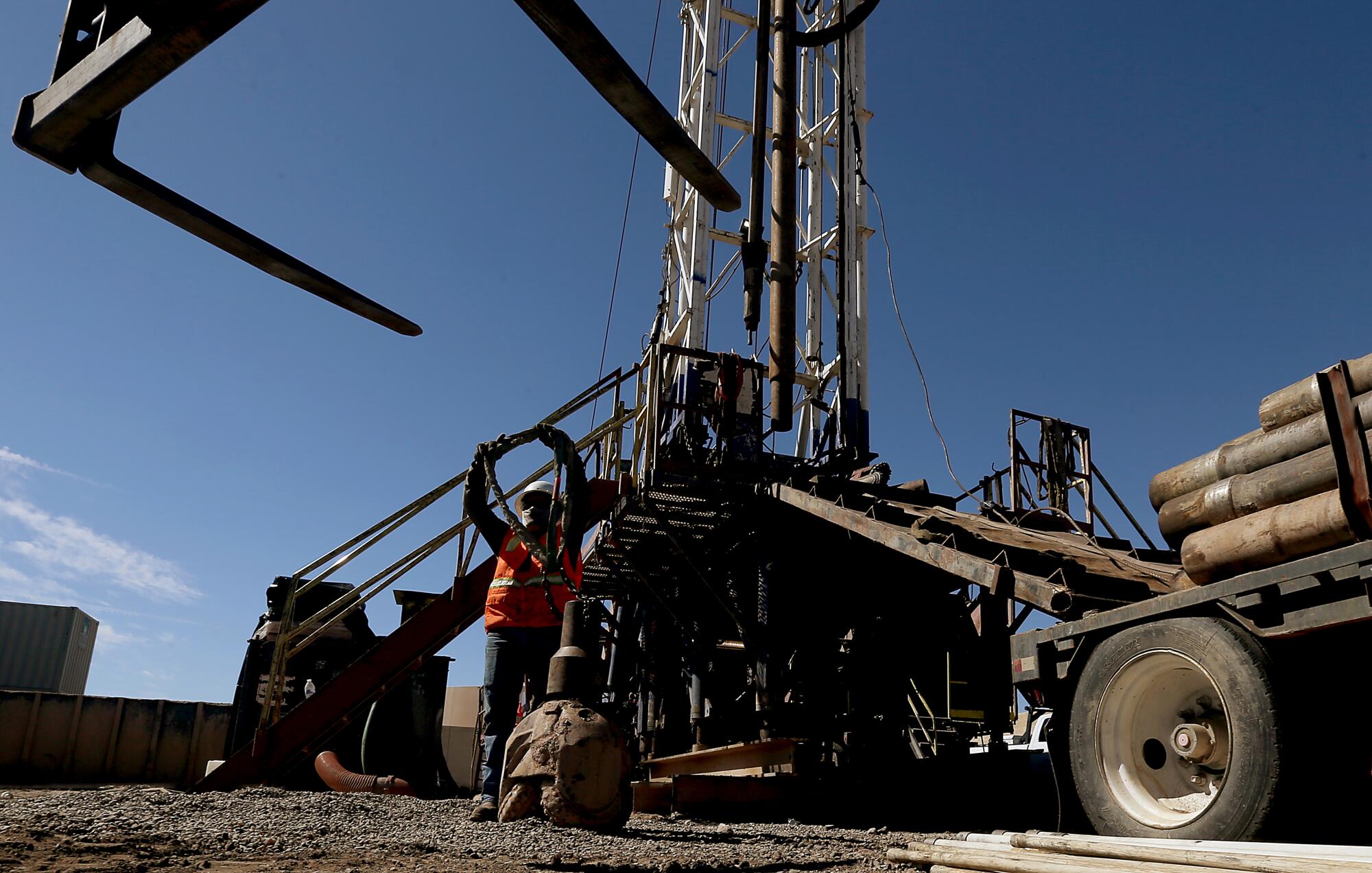 A workman prepares a rig to drill for water in the suburbs of Phoenix. 