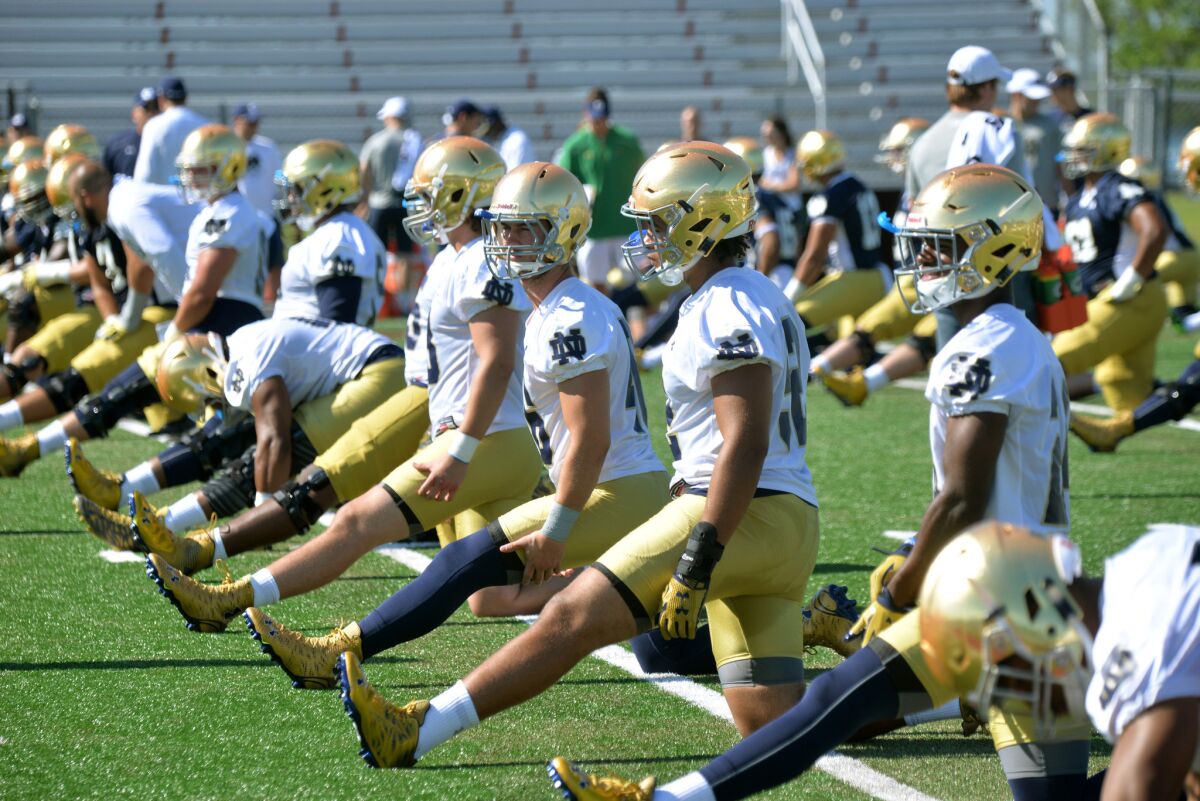 Notre Dame football players loosen up during a training camp practice on Aug. 7.