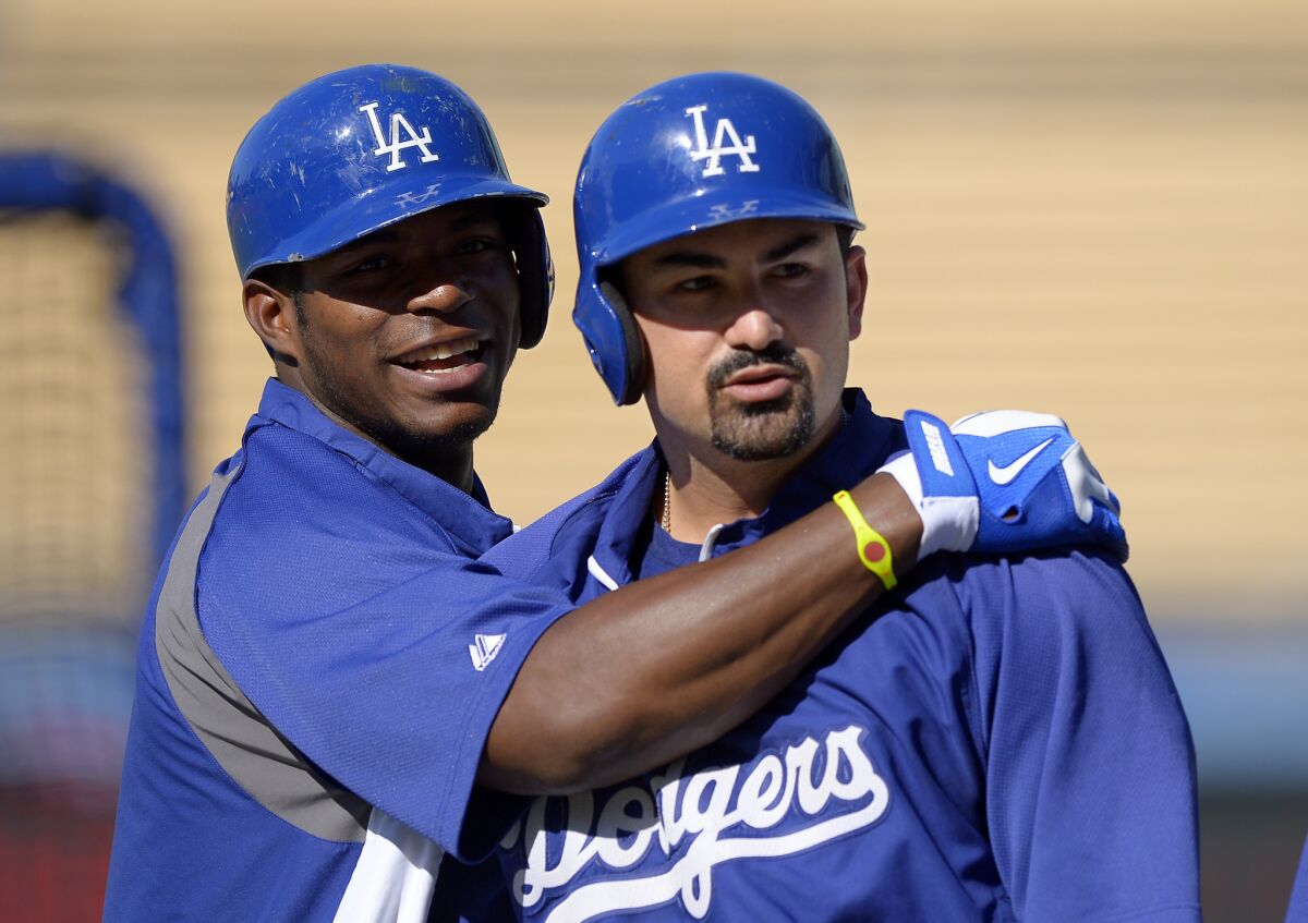 Dodgers rookie Yasiel Puig, left, gives teammate Adrian Gonzalez a hug during batting practice before their game against the Colorado Rockies on Friday.