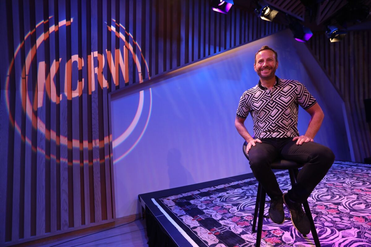 KCRW music director Jason Bentley sits on a stage inside the station's new studio where he's recently begun to broadcast "Morning Becomes Eclectic."