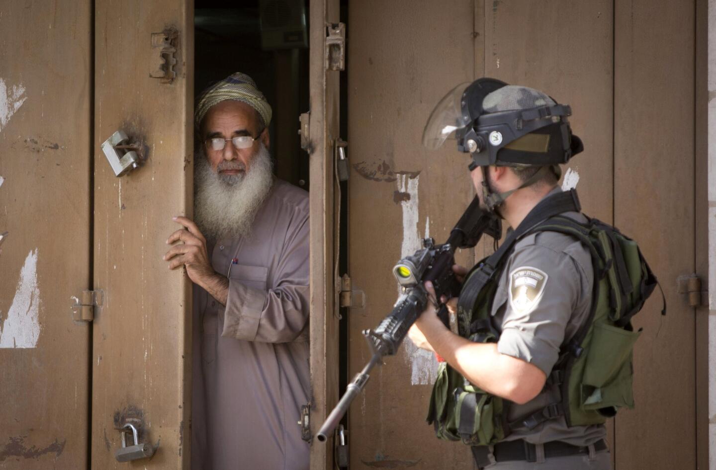 A Palestinian man closes his shop during clashes between Israeli troops and Palestinian protesters in the West Bank town of al-Ram on Oct. 22, 2015.