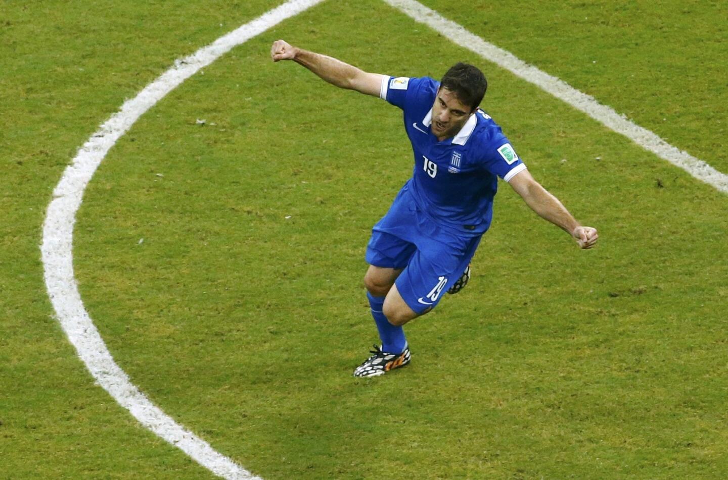 Greece's Sokratis Papastathopoulos celebrates after scoring a goal during the 2014 World Cup round of 16 game between Costa Rica and Greece at the Pernambuco arena