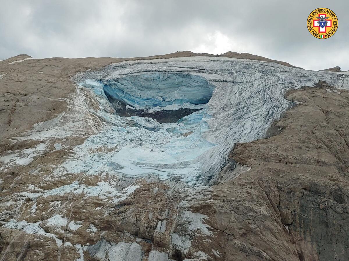 This image released on Sunday, July 3, 2022, by the Italian National Alpine and Cave Rescue Corps shows the glacier in Italy's Alps near Trento a large chunk of which has broken loose, killing at least six hikers and injuring eight others. Alpine rescue service officials, which provided that toll Sunday evening, said it could take hours to determine if any hikers might be missing. The National Alpine and Cave Rescue Corps tweeted that the search of the involved area of Marmolada peak involved at least five helicopters and rescue dogs. (Corpo Nazionale Soccorso Alpino e Speleologico via AP)