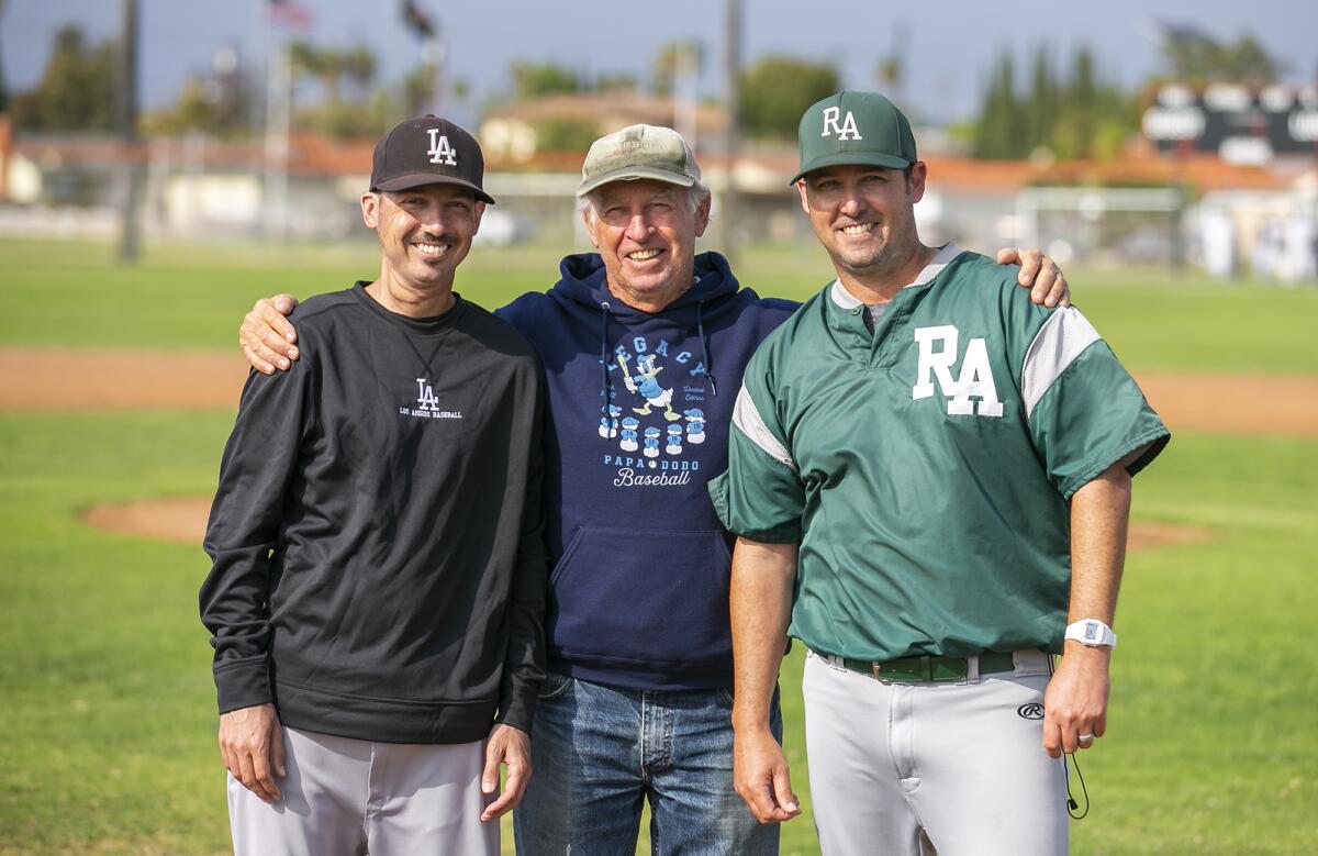 Los Amigos coach Aaron Pines, left, Rancho Alamitos coach Greg Pines, right, and their father Myron Pines pose for a photo.