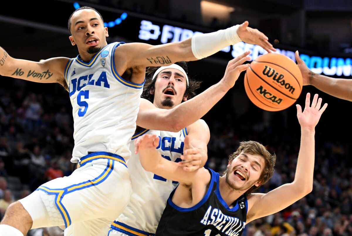 UCLA's Amari Bailey and Jaime Jaquez Jr. battle for a rebound with North Carolina Asheville's Fletcher Abee.