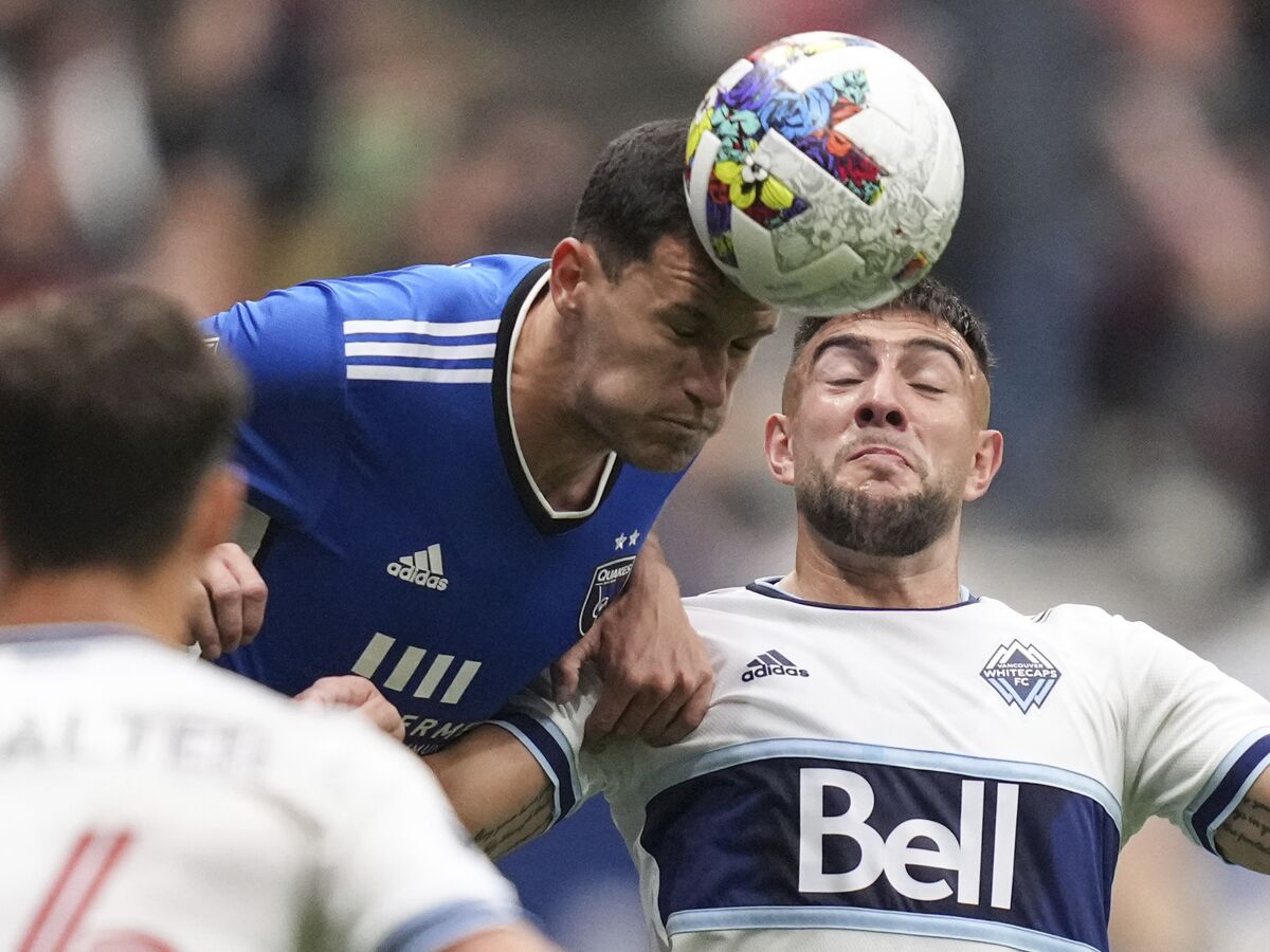 San Jose Earthquakes' Nathan, left, and Vancouver Whitecaps' Lucas Cavallini vie for the ball during the first half of an MLS soccer match Saturday, May 14, 2022, in Vancouver, British Columbia. (Darryl Dyck/The Canadian Press via AP)