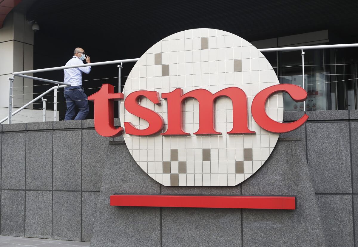 FILE - A person walks into the Taiwan Semiconductor Manufacturing Co., Ltd. (TSMC) headquarters in Hsinchu, Taiwan, on Oct. 20, 2021. Taiwan Semiconductor Manufacturing Co., the biggest contract manufacturer of processor chips, reported Thursday, Jan. 13, 2022, its quarterly profit rose 16.4% over a year earlier to $6 billion amid surging demand for chips for smartphones and other electronics.(AP Photo/Chiang Ying-ying, File)