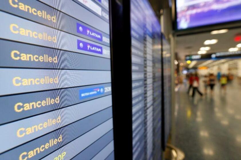 FILE - In this Sept. 8, 2017, file photo, a monitor is shown listing cancelled flights at Miami International Airport in Miami. In addition to residents affected by Hurricane Irma in Florida and the Caribbean, thousands of travelers' vacation plans have been disrupted by cancelled flights, cruises that changed course and hotels and attractions that closed or were damaged by the storm. (Wilfredo Lee/AP Photo, File