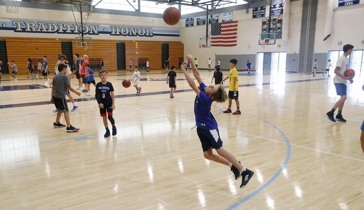 Campers, during a break, shoot dreamy baskets as well as dribble and wait for the next drills at the Coach Z Basketball Camp at Crescenta Valley High School on Monday, July 22, 2019. Coach Shawn Zargarian coordinated basketball drills with helping coaches to keep about 50 youth basketball enthusiasts busy.