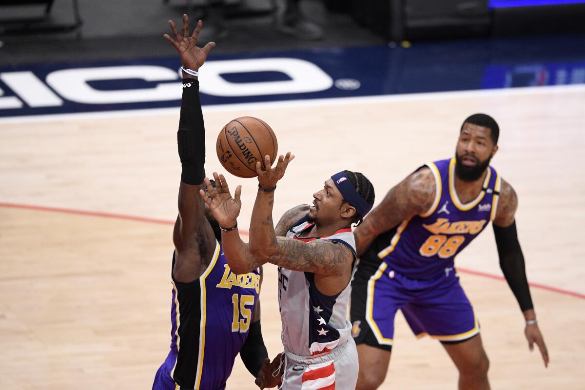 Washington Wizards guard Bradley Beal goes to the basket against Lakers center Montrezl Harrell and forward Markieff Morris.