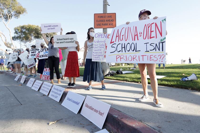 Candice Dartez, right, who has a senior and an 8th grader, demonstrates with other parents to open Thurston Middle School, Laguna Beach High School, and also to protest the LBUSD decision to send elementary school students back for hybrid learning.