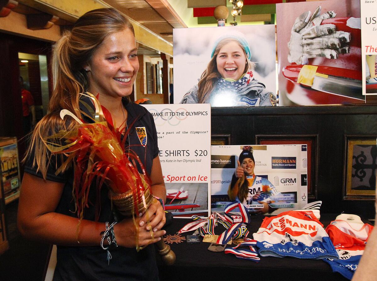 File Photo: Kate Hansen, a La Cañada High School graduate, holds an Olympic torch decoration from the 1984 Olympics for a photo at Los Gringos Locos for a fundraiser to help raise money for her to train with the USA Women's Olympic Luge Team in August 2013. Hansen slid to a victory in women's single luge on Saturday, Jan. 25, 2014.