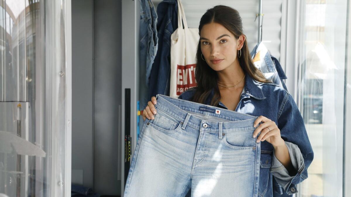 Model Lily Aldridge displays a pair of jeans she personalized at Levi's temporary studio in downtown Los Angeles.