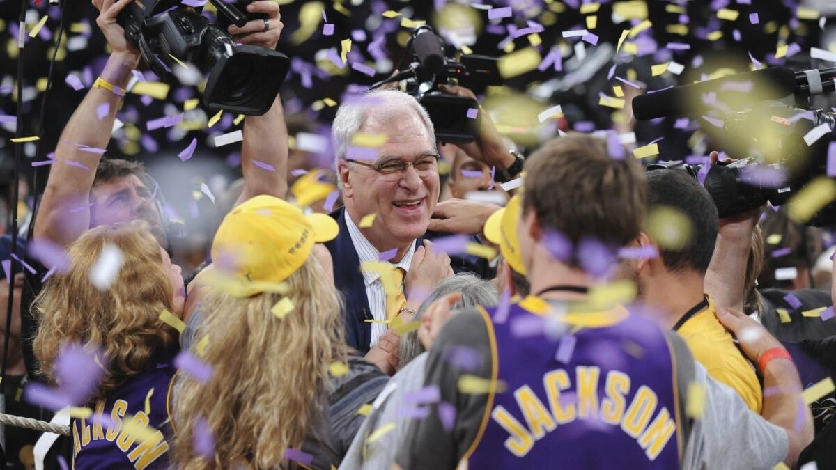 Phil Jackson celebrates with fans after the Lakers defeated the Boston Celtics to win the NBA title in 2010.