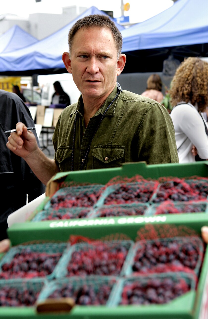 Mark Peel in front of produce at a market. 
