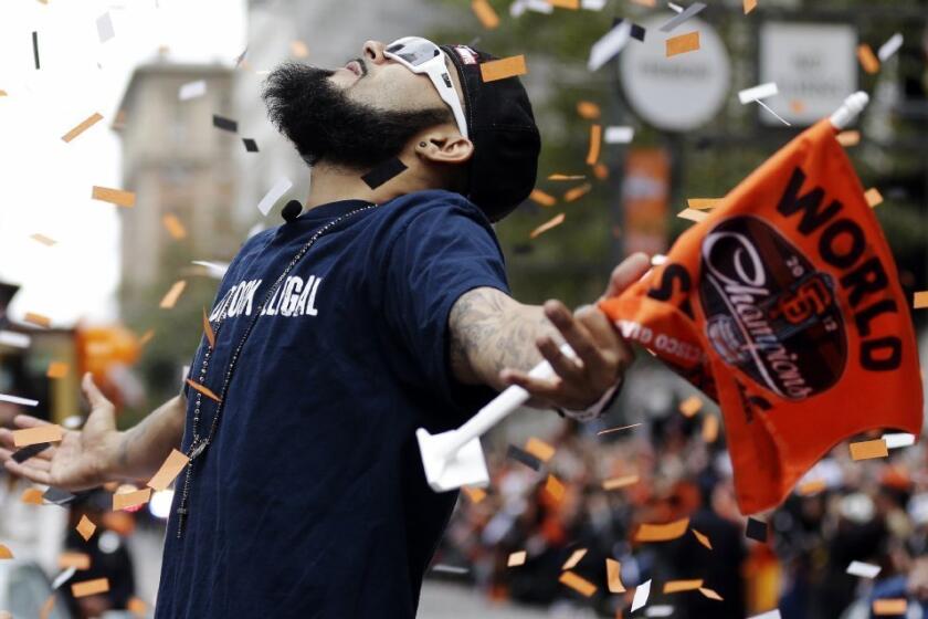 San Francisco Giants pitcher Sergio Romo looks up as confetti falls during the baseball team's World Series victory parade in San Francisco.