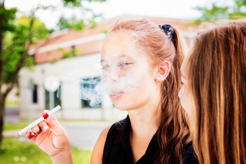 Preteen girl tries e-cigarette under the influence of her friend. User Upload Caption: Results of a recent survey found that 12- to 14-year-olds who had tried e-cigs were 2.5 times more likely to become heavy marijuana users, smoking pot at least once a week. ** OUTS - ELSENT, FPG - OUTS * NM, PH, VA if sourced by CT, LA or MoD **
