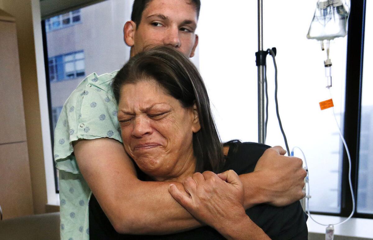 Paula Carney embraces her son Joey in his hospital room before they each head off to surgery on June 2.