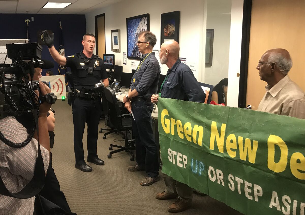 Activists protested outside Rep. Scott Peters office in University City urging him to sign onto the Green New Deal on July 19, 2019. During a more recent protest on Sept. 26, protesters barged into his office.