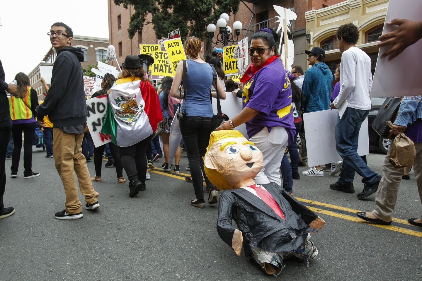 One protester carries a piñata in the likeness of Donald Trump as a group of anti-Trump protesters march down 5th Avenue as they head toward the San Diego Convention Center.