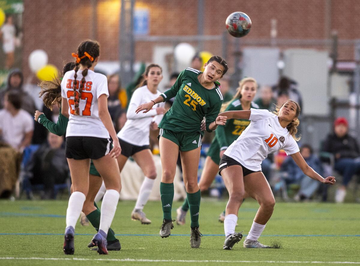 Edison's Lucy Curren and Huntington Beach's Jaiden Anderson go up for a header during a Surf League finale on Wednesday.