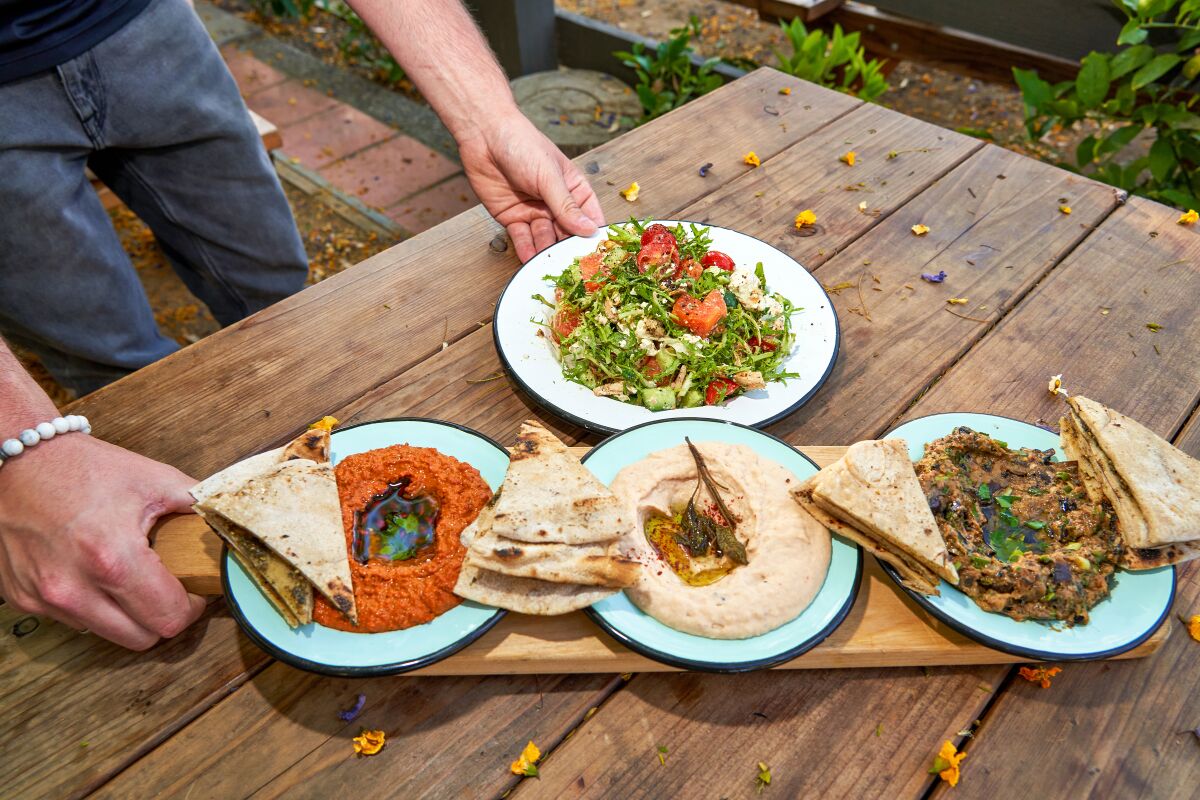 Hummus, charred eggplant, muhammara and grilled manouche at Ojai Rotie, a French-Lebanese patio restaurant, in Ojai, Calif.