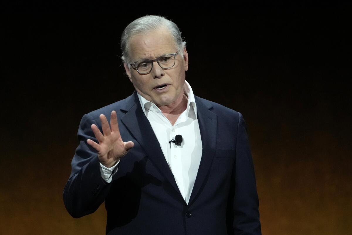 David Zaslav holds a hand up while speaking.