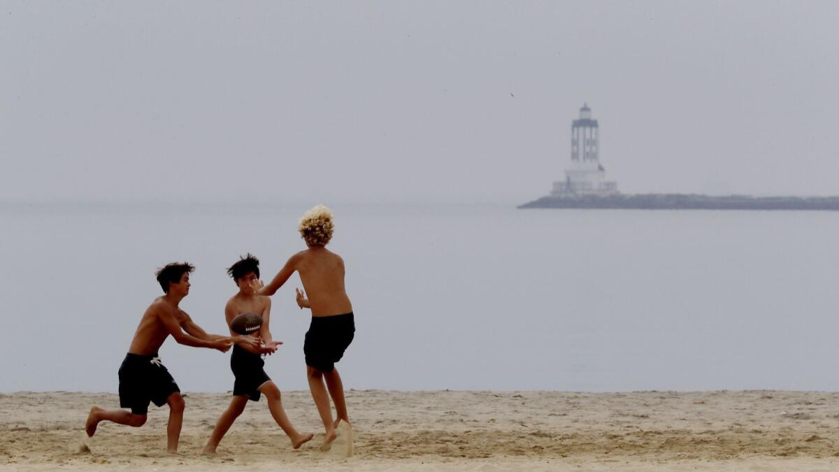 Junior lifeguards play football on Cabrillo Beach in San Pedro. Cabrillo Beach (harborside), Heal the Bay’s “Beach Bummer” list, is enclosed by a seawall and the absence of large waves makes it a popular beach for families.