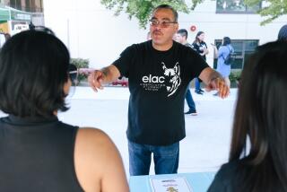 Student body president at East Los Angeles College, Steven Gallegos, center, informs stalls about a photobooth.