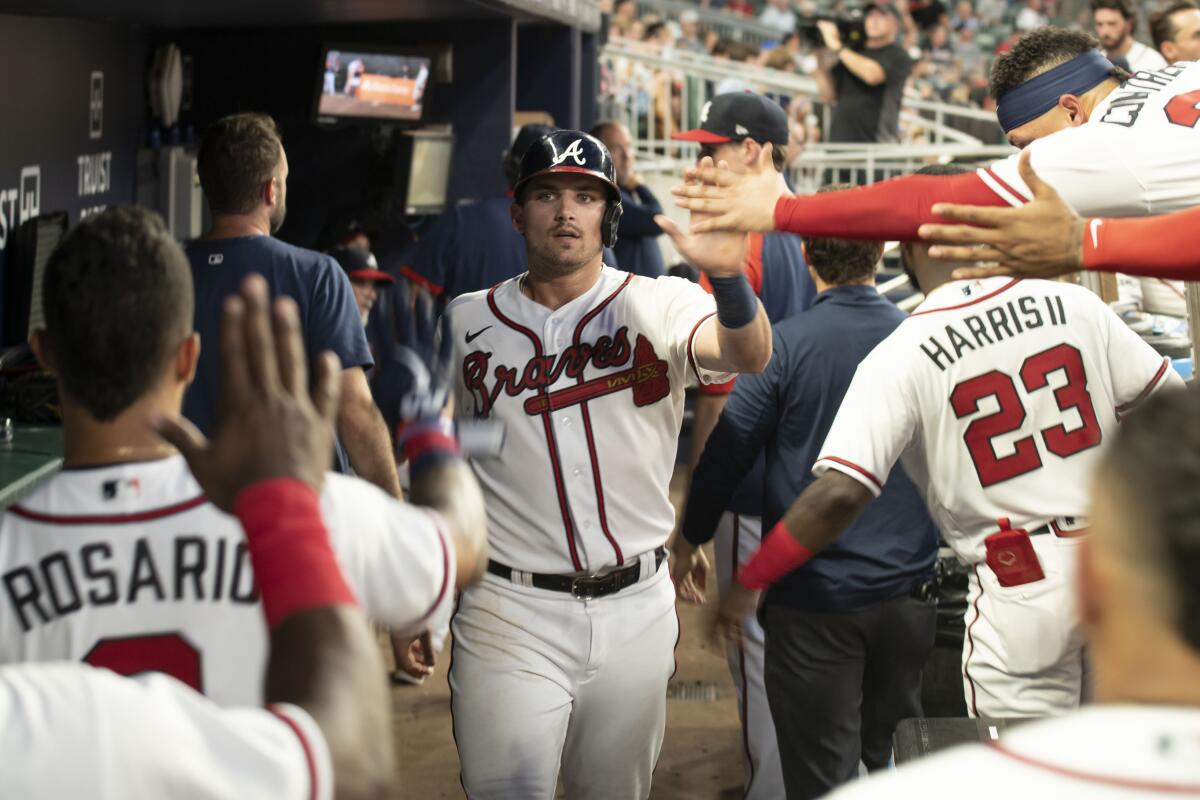 Atlanta Braves' Austin Riley returns to the dugout after scoring an RBI in the sixth inning of a baseball game against the St. Louis Cardinals Wednesday, July 6, 2022, in Atlanta. (AP Photo/Edward M. Pio Roda)