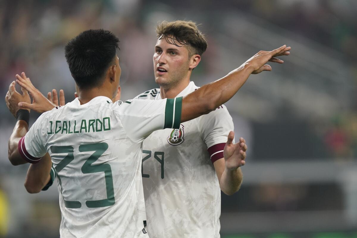 Jesús Gallardo (23) festeja con Santiago Giménez, quien anotó un gol de la selección de México 