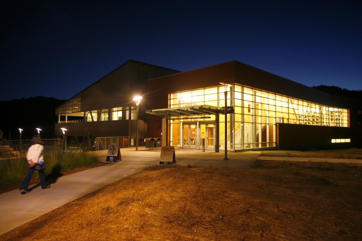 The glass panels of the Library Learning Center at Mendocino College in Ukiah glow at twilight. Many rural institutions are fighting to meet enrollment goals on which the state bases its funding.