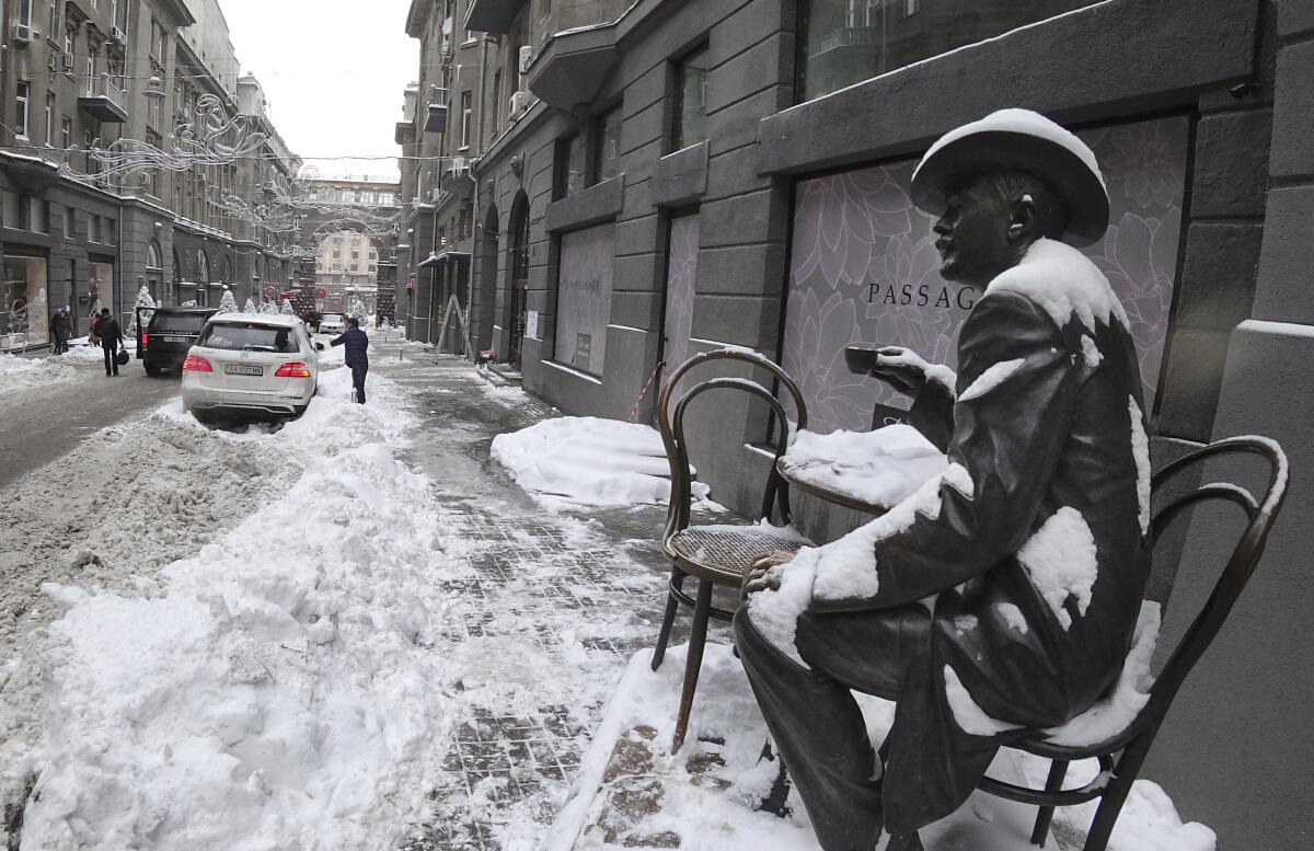 A monument to famous architect Vladislav Gorodetsky is shown covered in snow Kyiv's city center