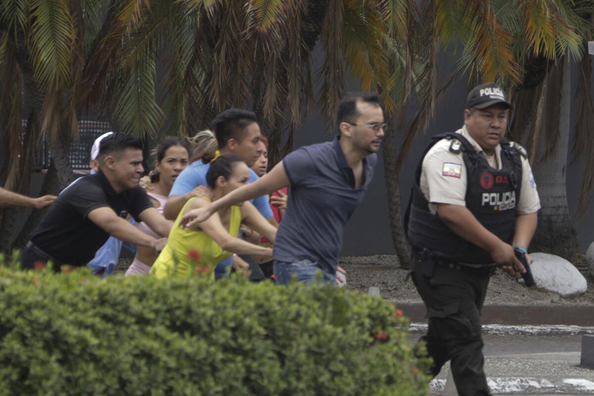 Police evacuating staff from an Ecuadorean TV studio stormed by armed attackers