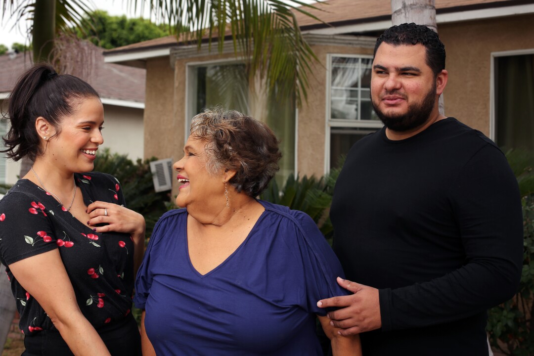 Maria Guadalupe “Lupita” Olague smiles with her twin children, Luz and Raul Arango, at their home in Pico Rivera