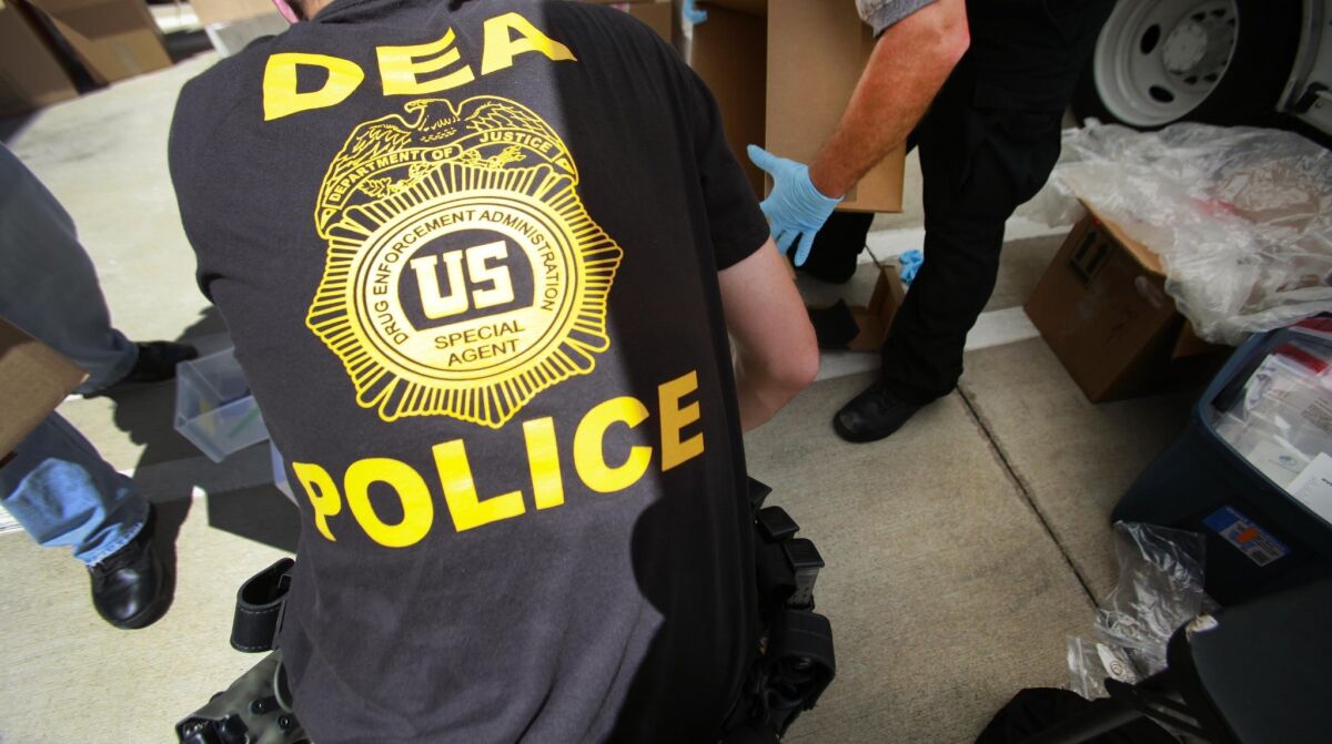 DEA agents unload drugs and weapons for a news conference in 2016.